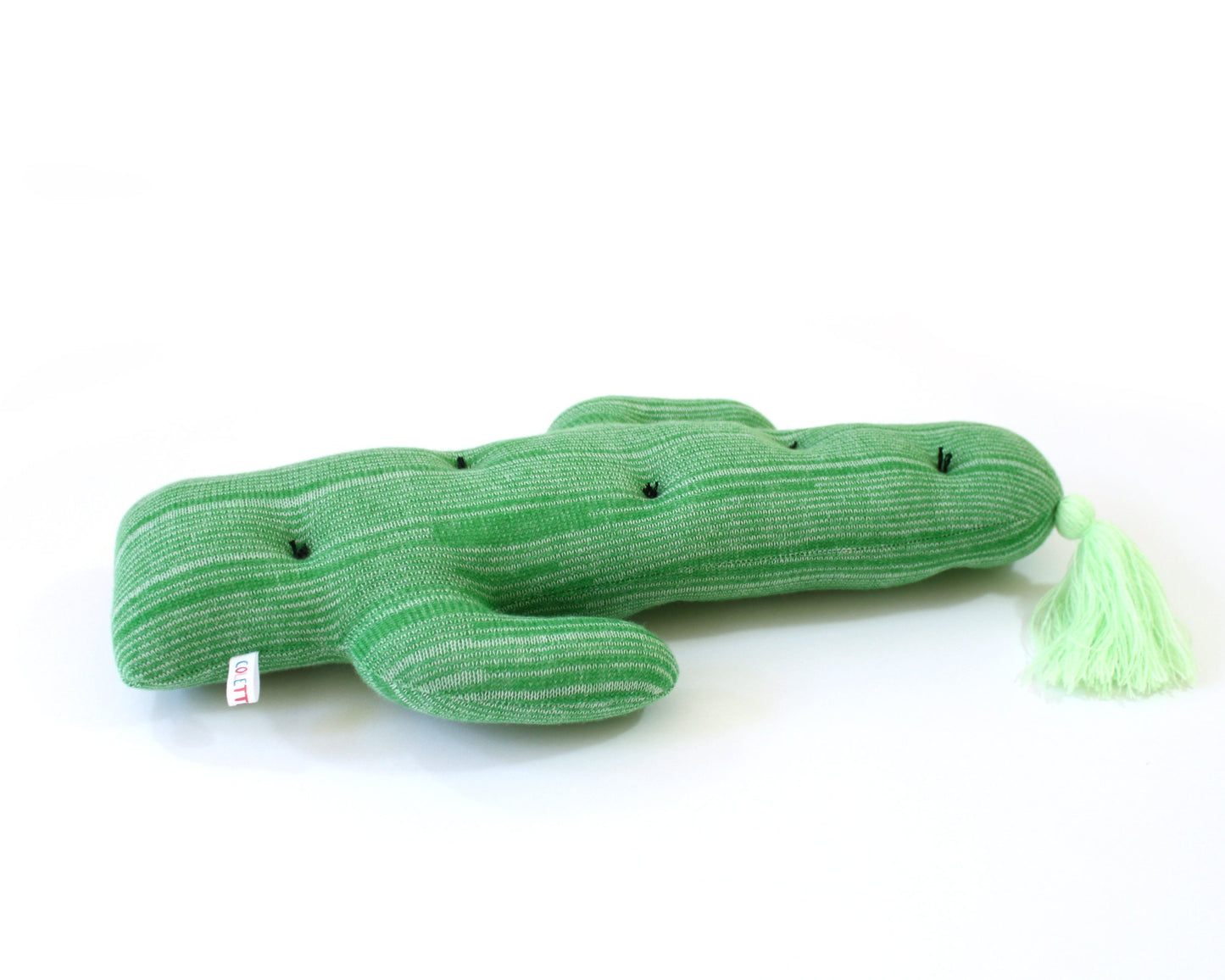 Green cactus-shaped plush toy with a tassel on a white background