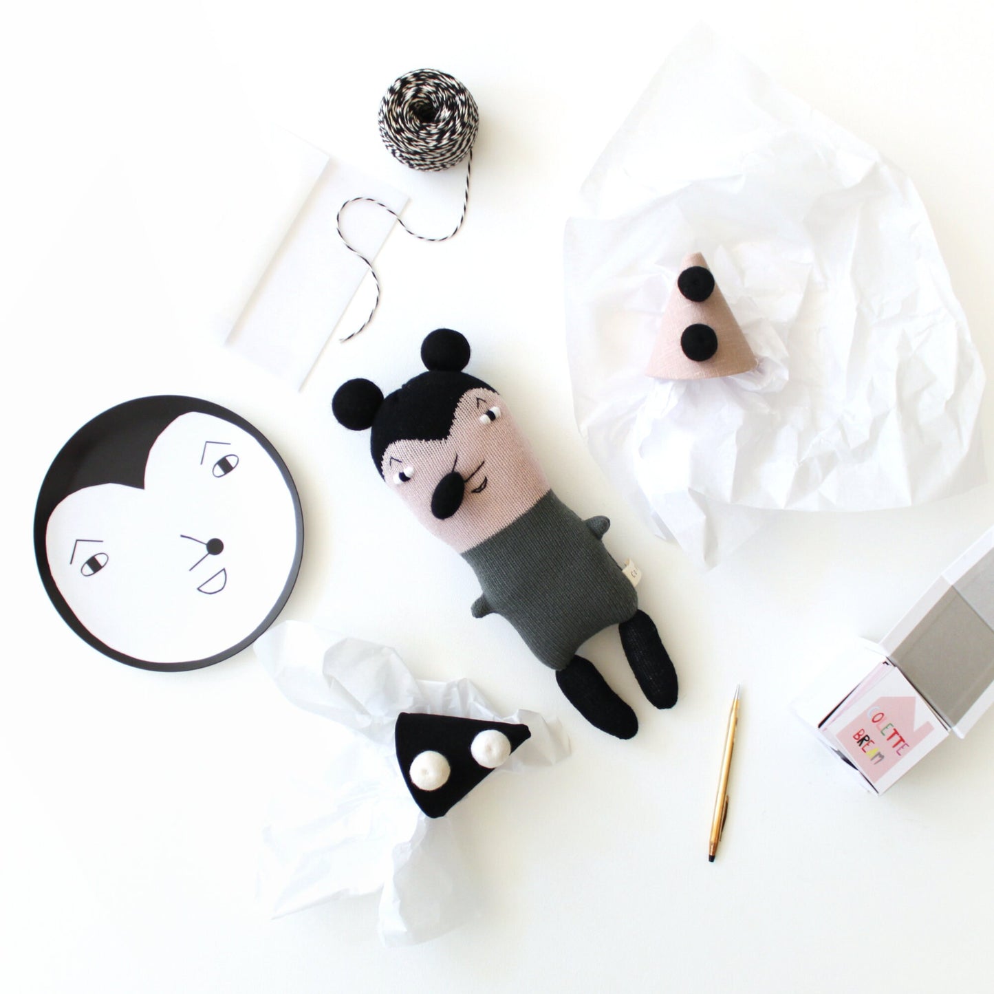 Handmade knitted plush toy mouse with black and white design on a white background