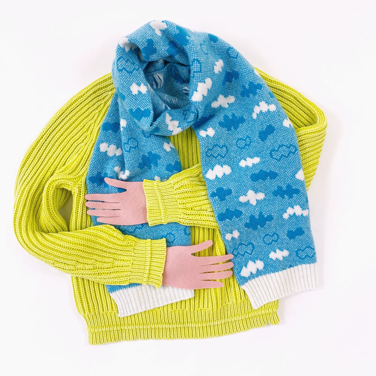 Yellow sweater with blue cloud patterned lambswool scarf on a white background