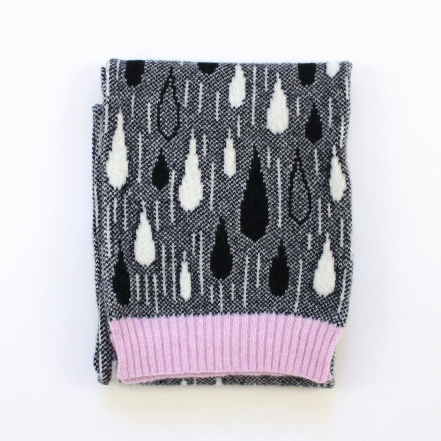 Knit scarf with black and white raindrop pattern and pink trim on a white background