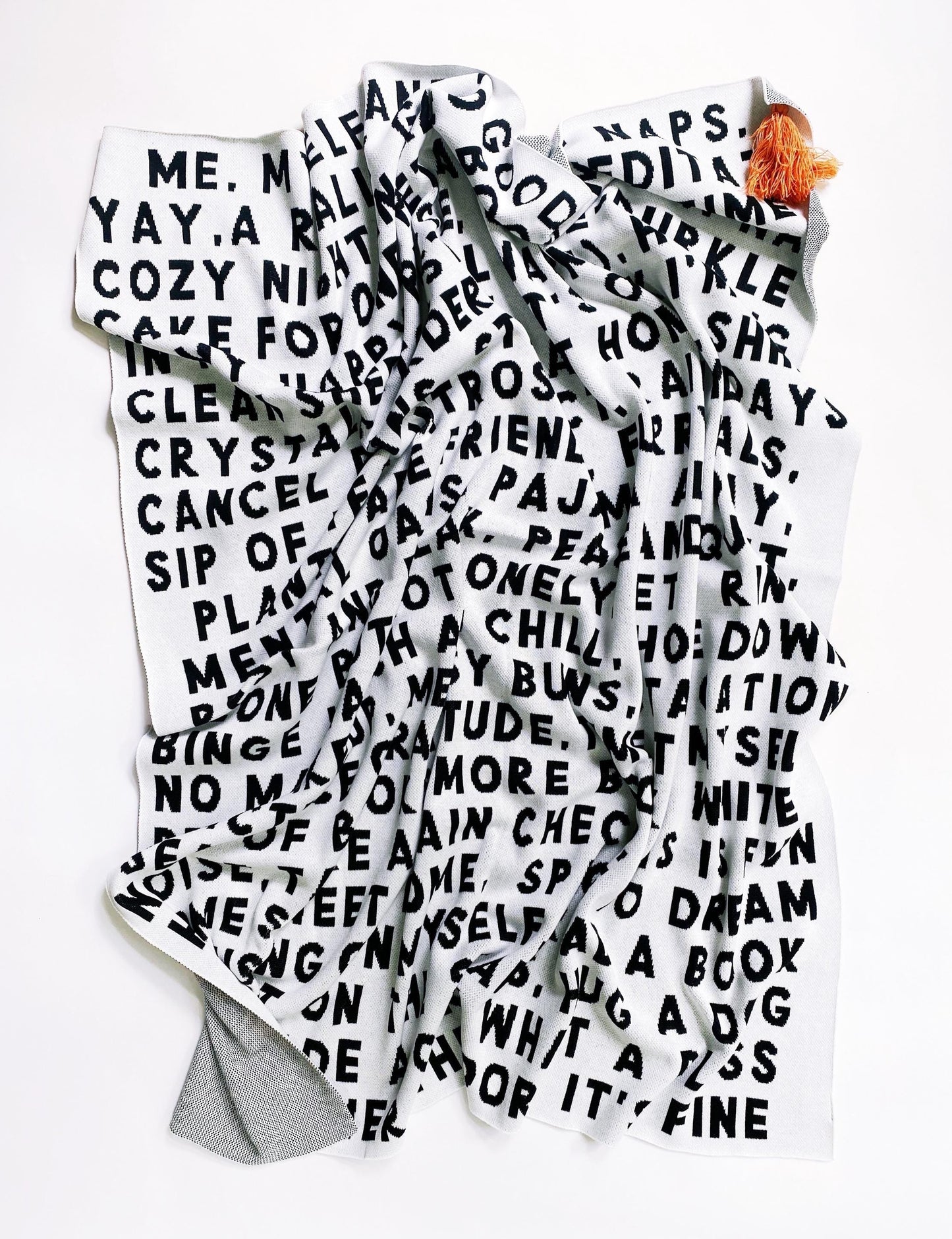 Large knitted blanket throw with black and white text on a white background