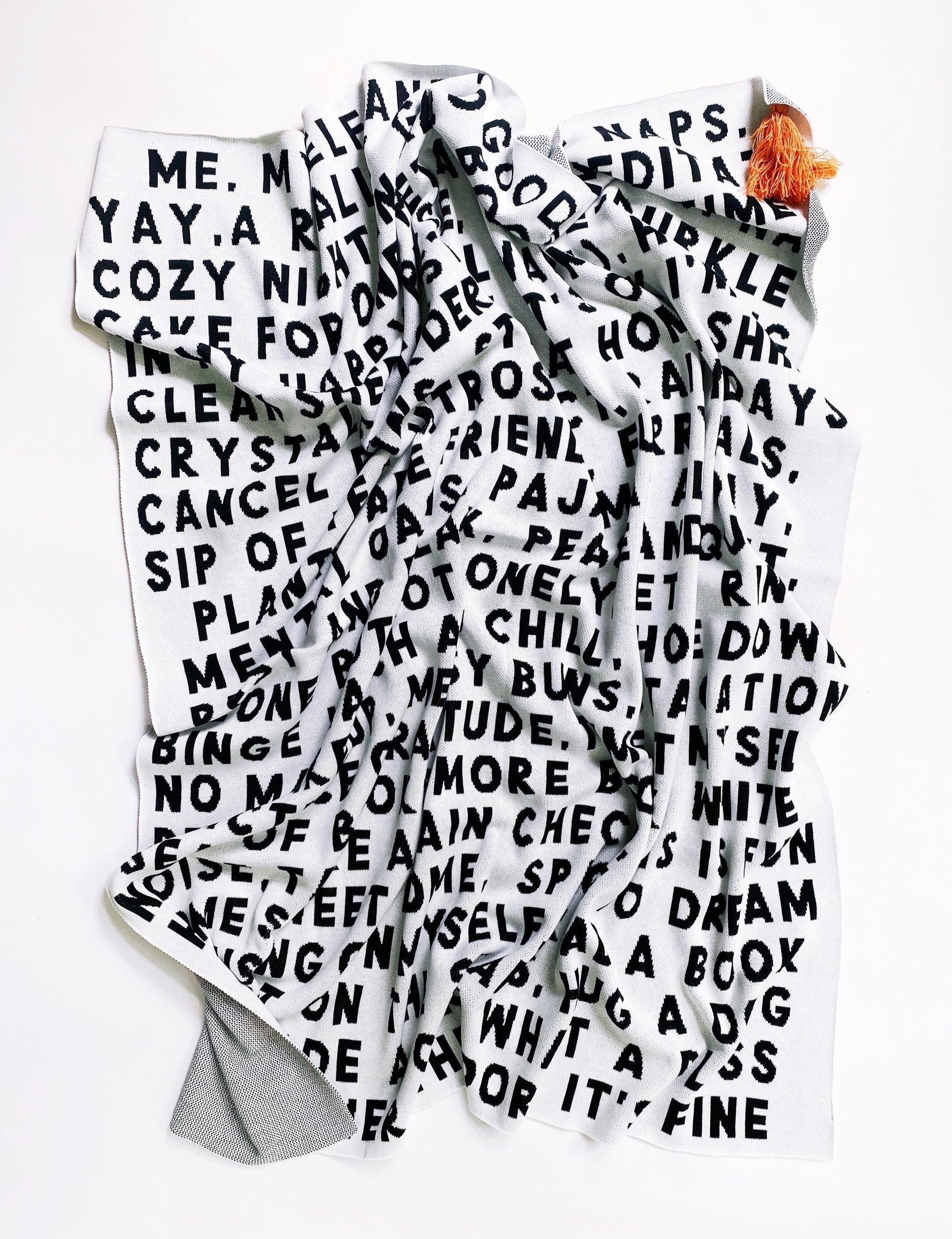 Large knitted blanket throw with black and white text on a white background