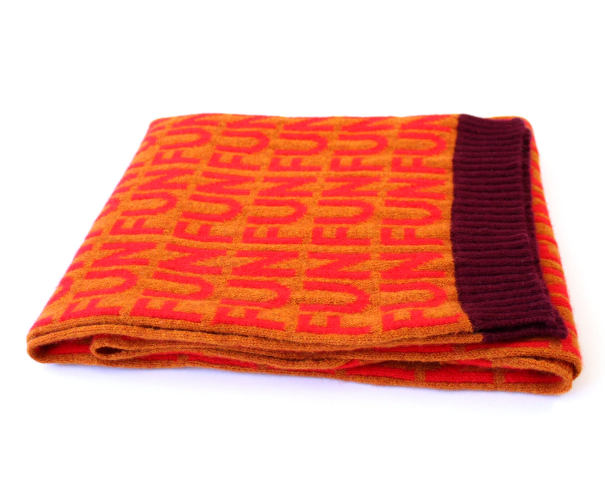 Folded knitted scarf with 'FUN' pattern on a white background