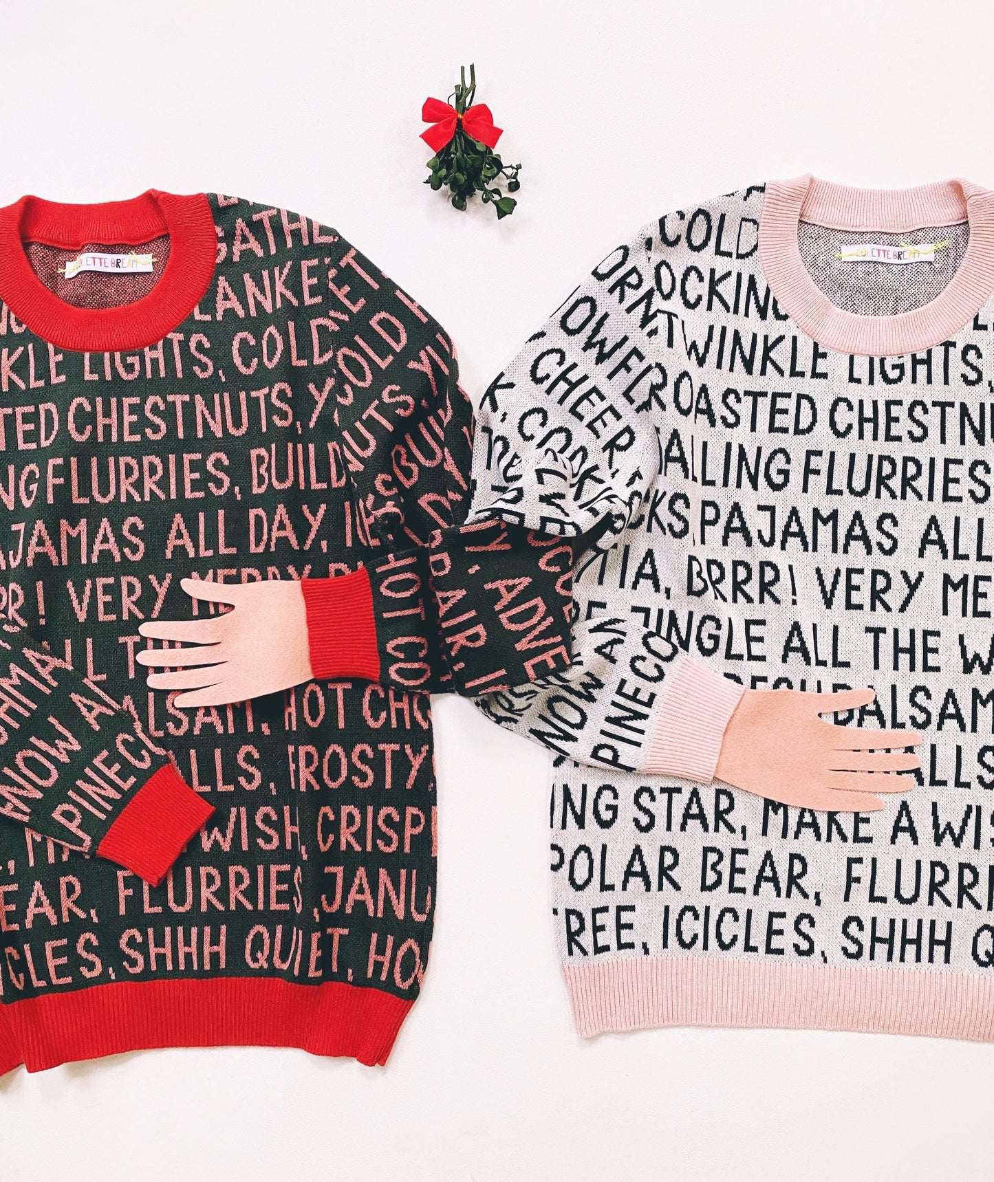 Two sweaters with festive christmas text patterns on a white background