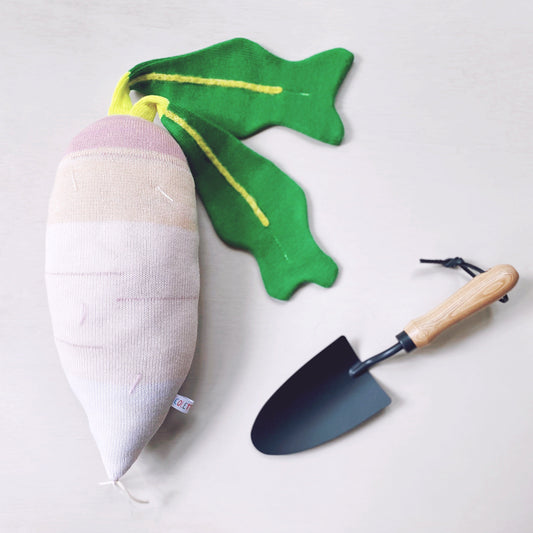 Knitted Turnip pillow plush and radish with green leaves and a small trowel on a white background