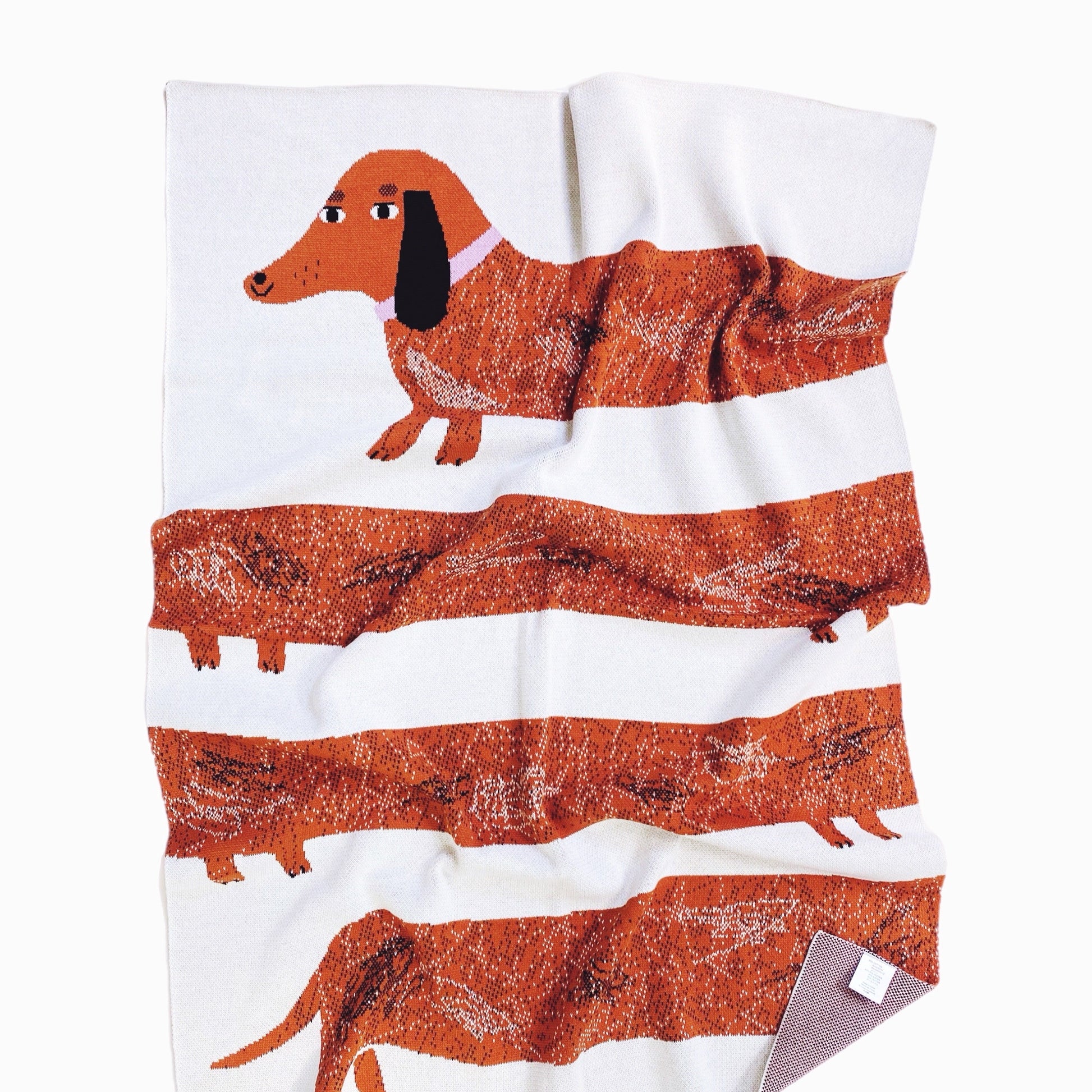 Knitted blanket with dachshund design on a white background