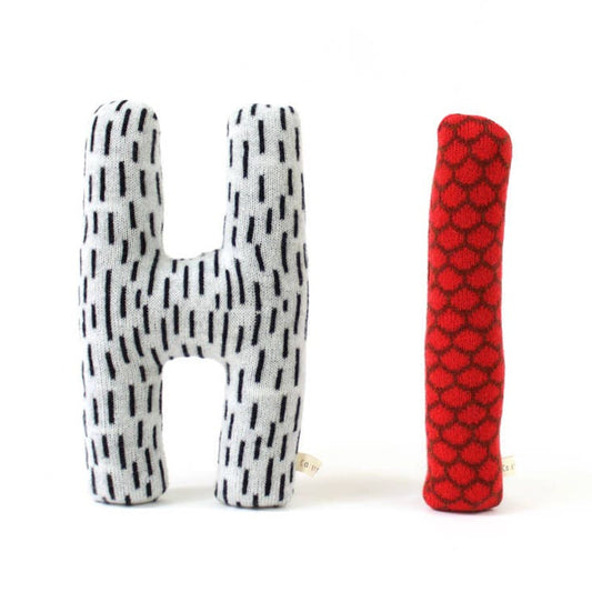 Letters 'Hi' plush toy pillow with black and white and red pattern on white background 