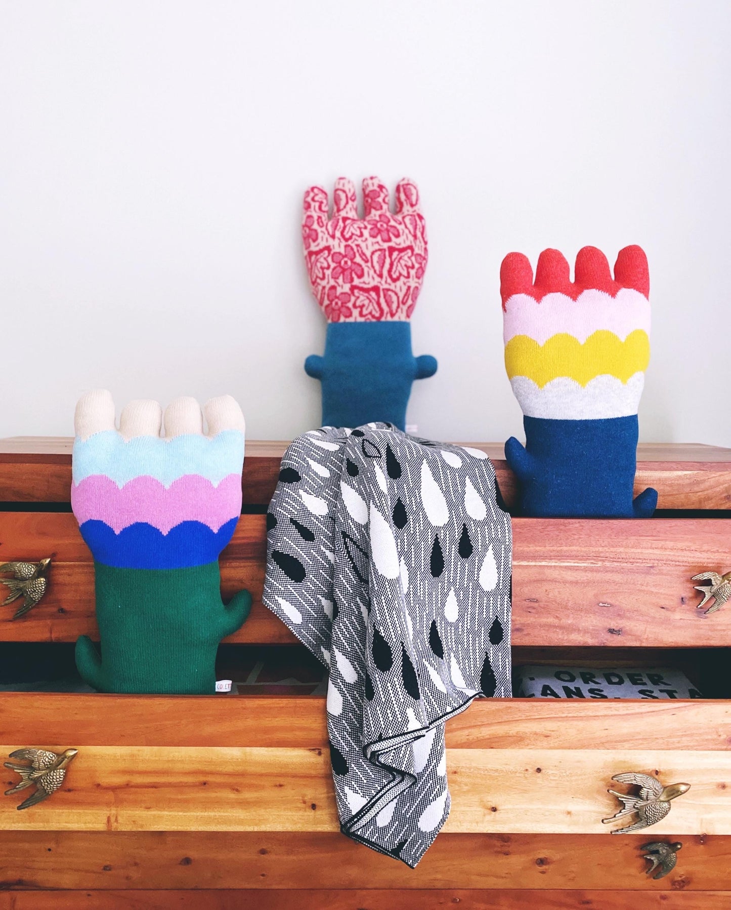 Colorful flower shaped pillows on a wooden surface with a white background