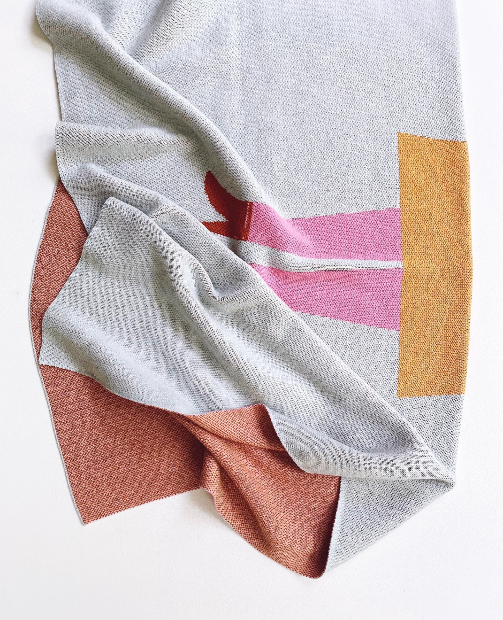 Folded knit fabric with geometric pattern on a white background