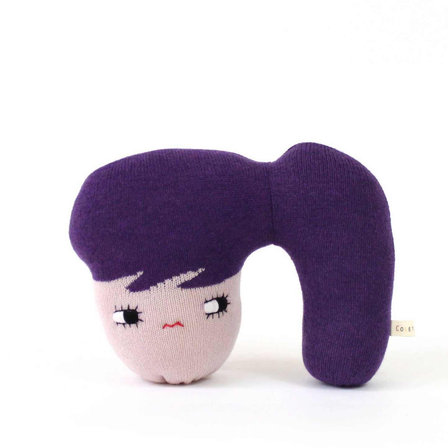 Soft knit doll with a face design and ponytail on a white background