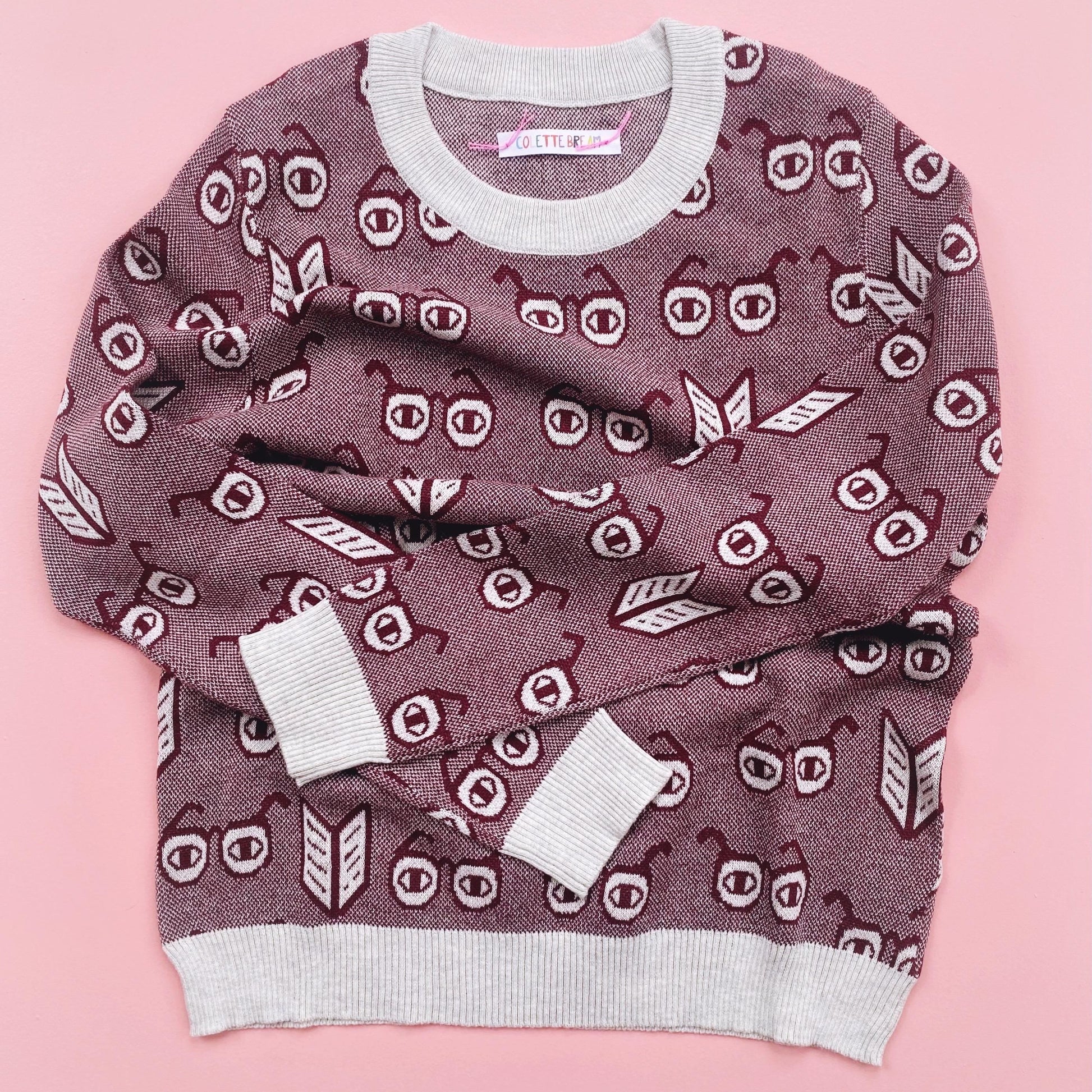 Knit Sweater with a unique pattern of spectacles glasses on a pink background background
