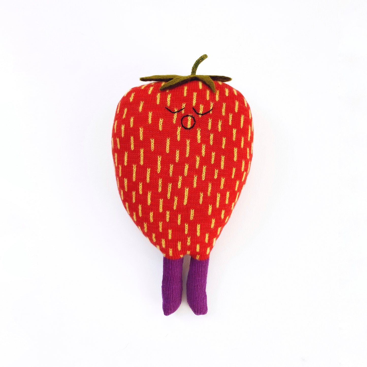 Plush toy shaped like a strawberry with a face on a white background