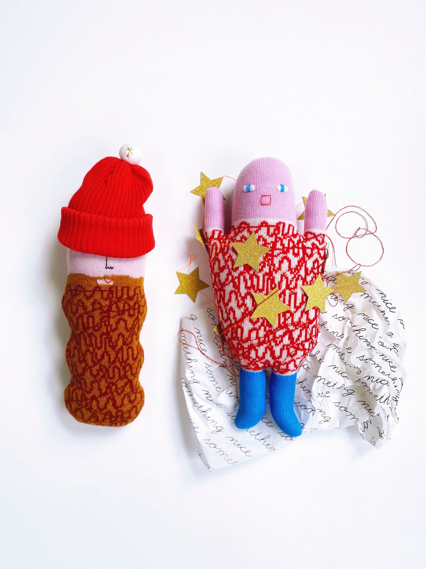 Two lambswool knitted plush toys, one beardy man and the other scaredy sue on a white background