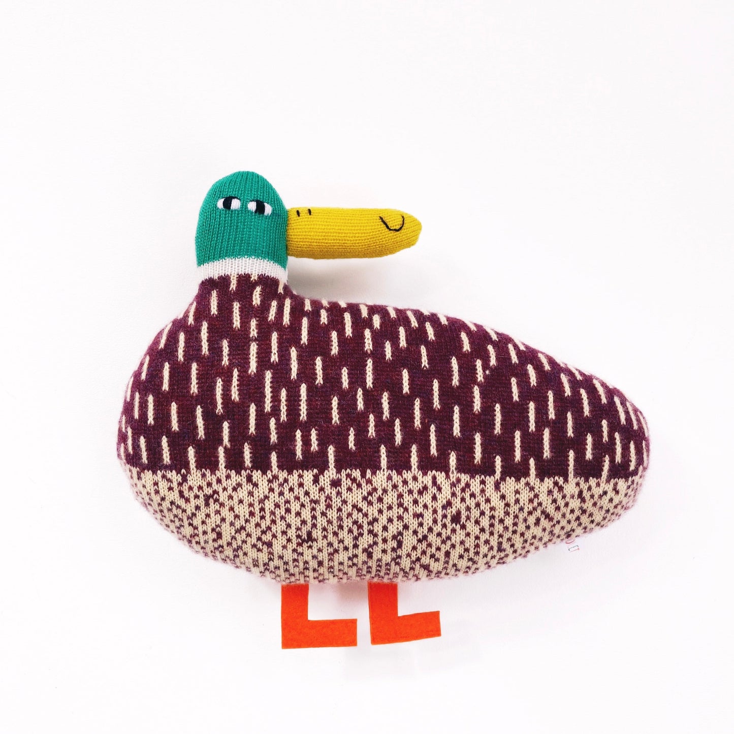 Plush toy knitted lambswool duck with a patterned body on a white background