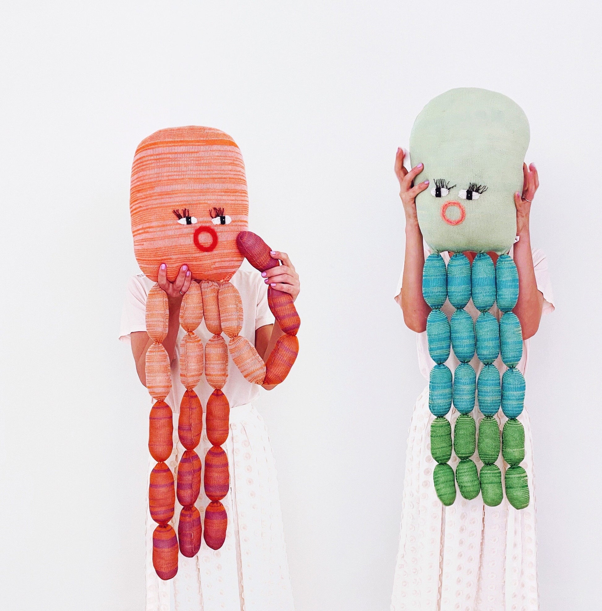Two colorful knitted plush toys resembling an octopus and a jellyfish on a white background