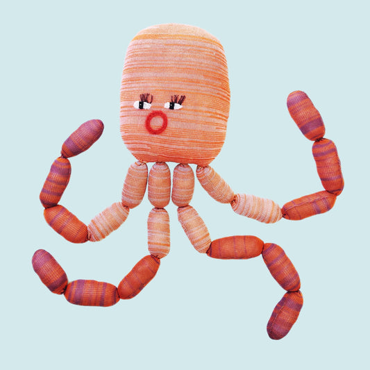 Large knitted octopus toy on a light blue background