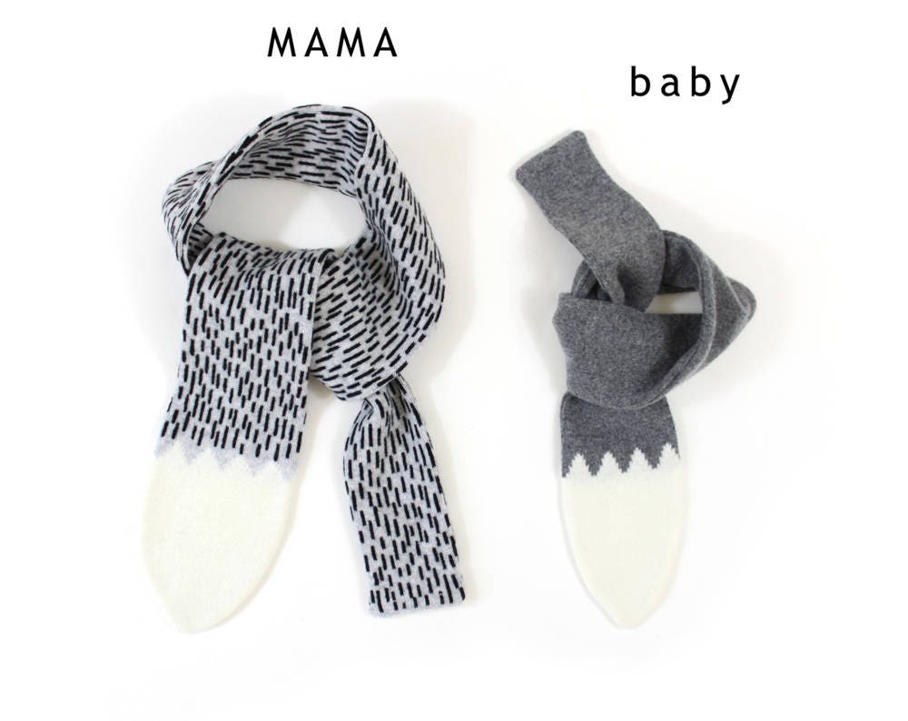 Two gray knitted lambswool scarves shaped like a wolf tail on a white background.