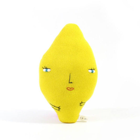 Yellow knitted lemon-shaped plush toy with a face on a white background