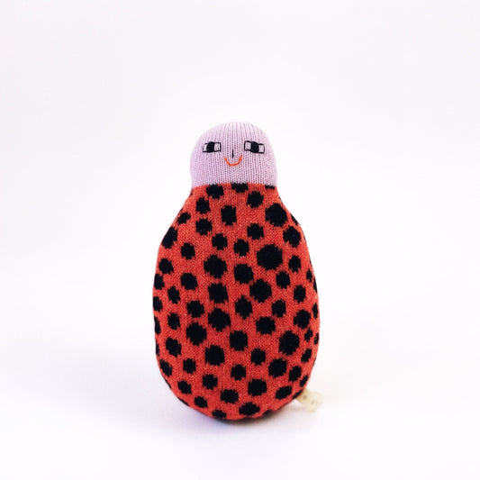 Knitted ladybug toy with a smiling face on a white background