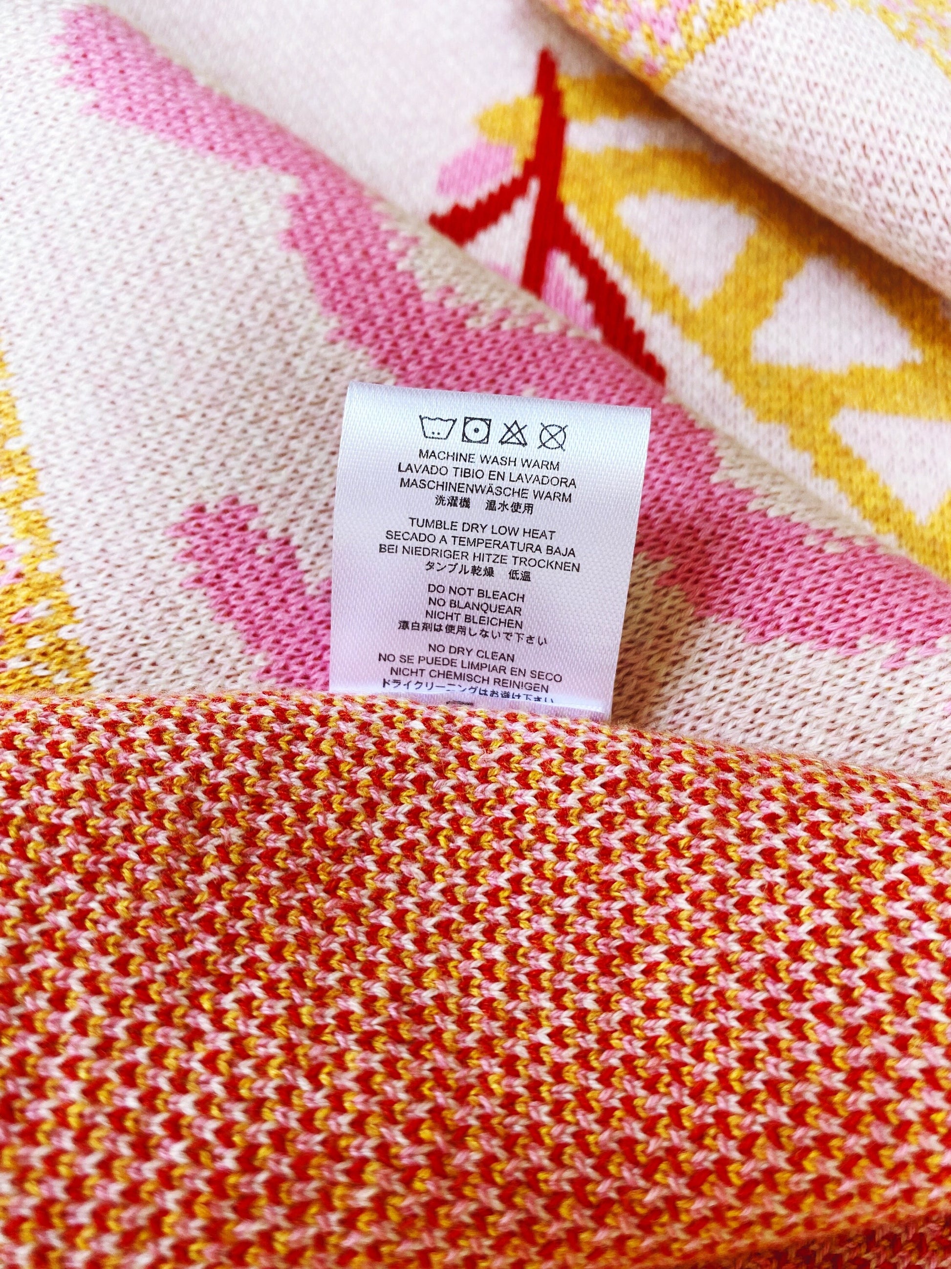 Close-up of a colorful knit fabric with a care label on a multicolored background