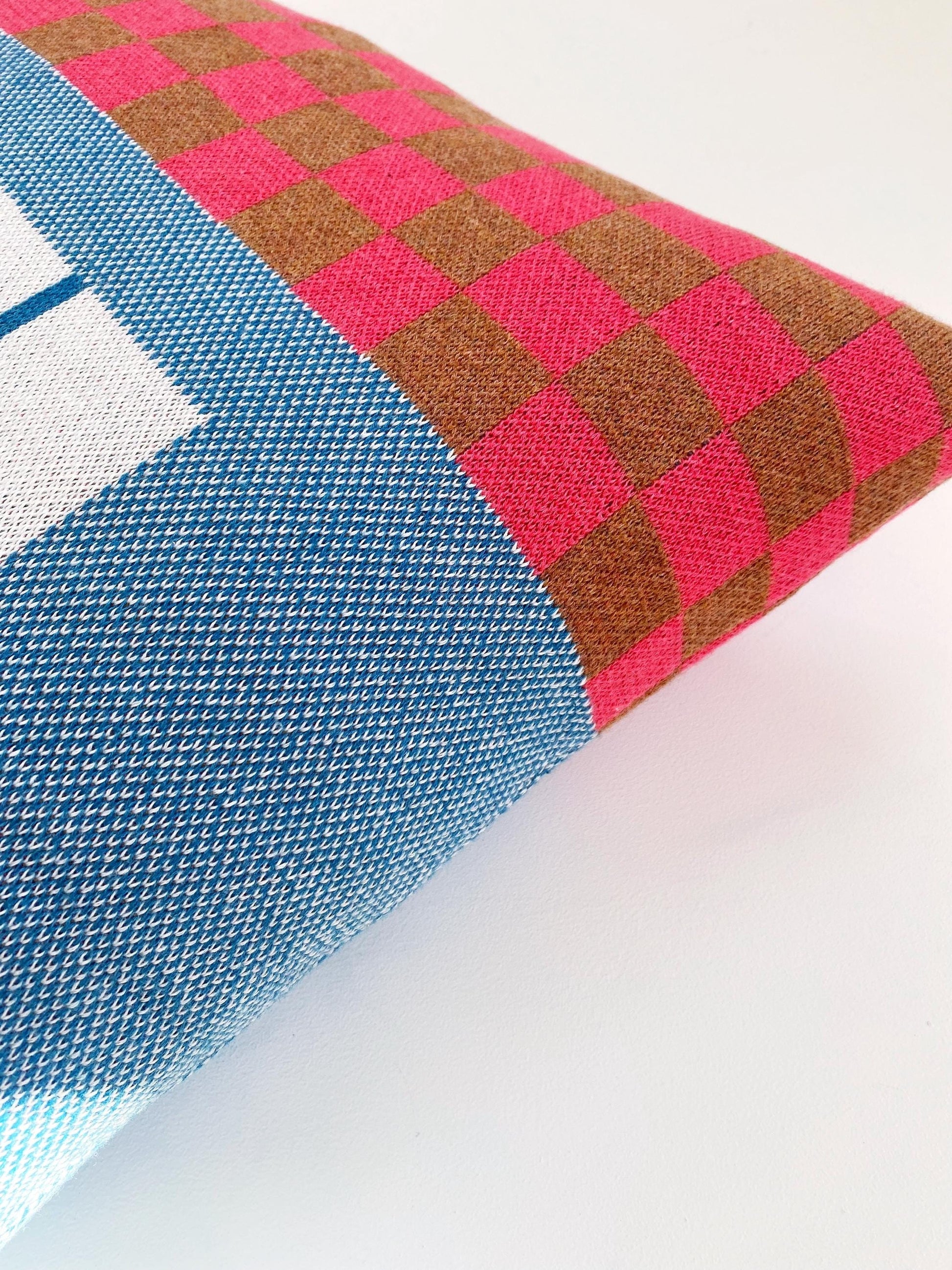 Close-up of a knitted fabric with a checkered pattern on a white background