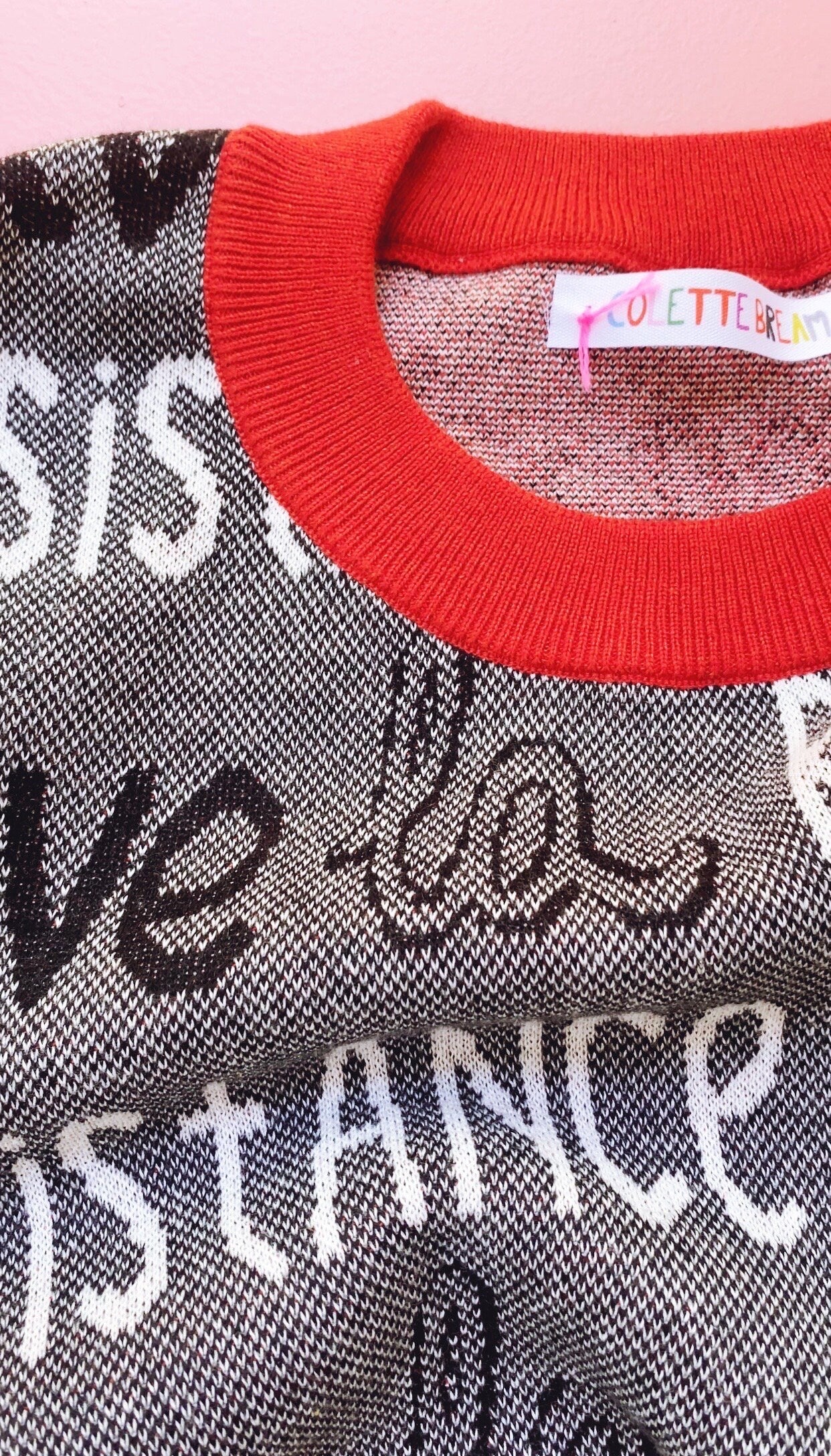 Textured sweater with red neckline and visible Colette Bream brand tag on a pink background