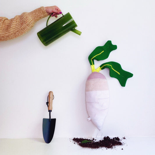 Decorative plant with a watering can and trowel on a white background, featuring the brand 'Colette Dream'.