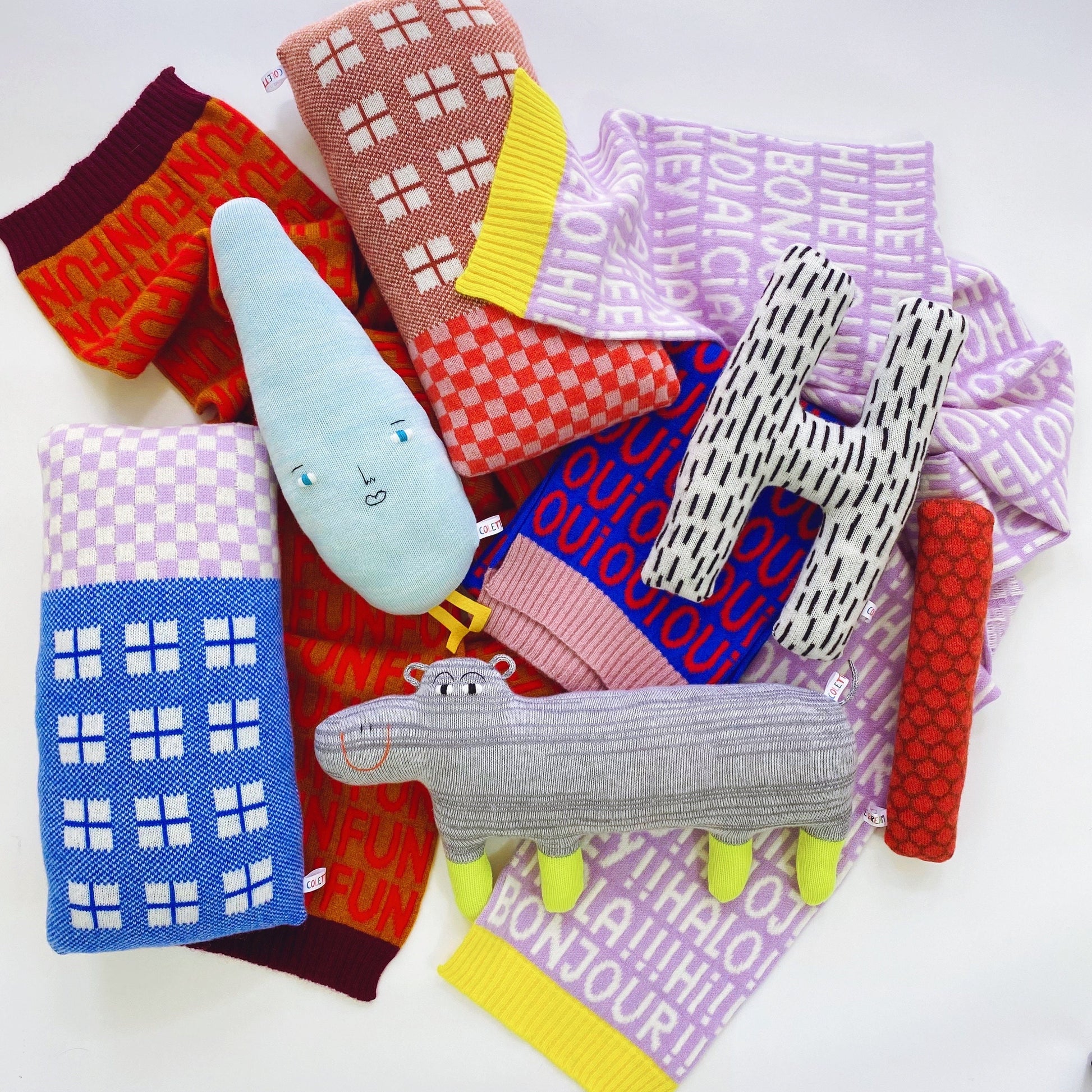 Collection of colorful knitted plush toys with various patterns on a white background