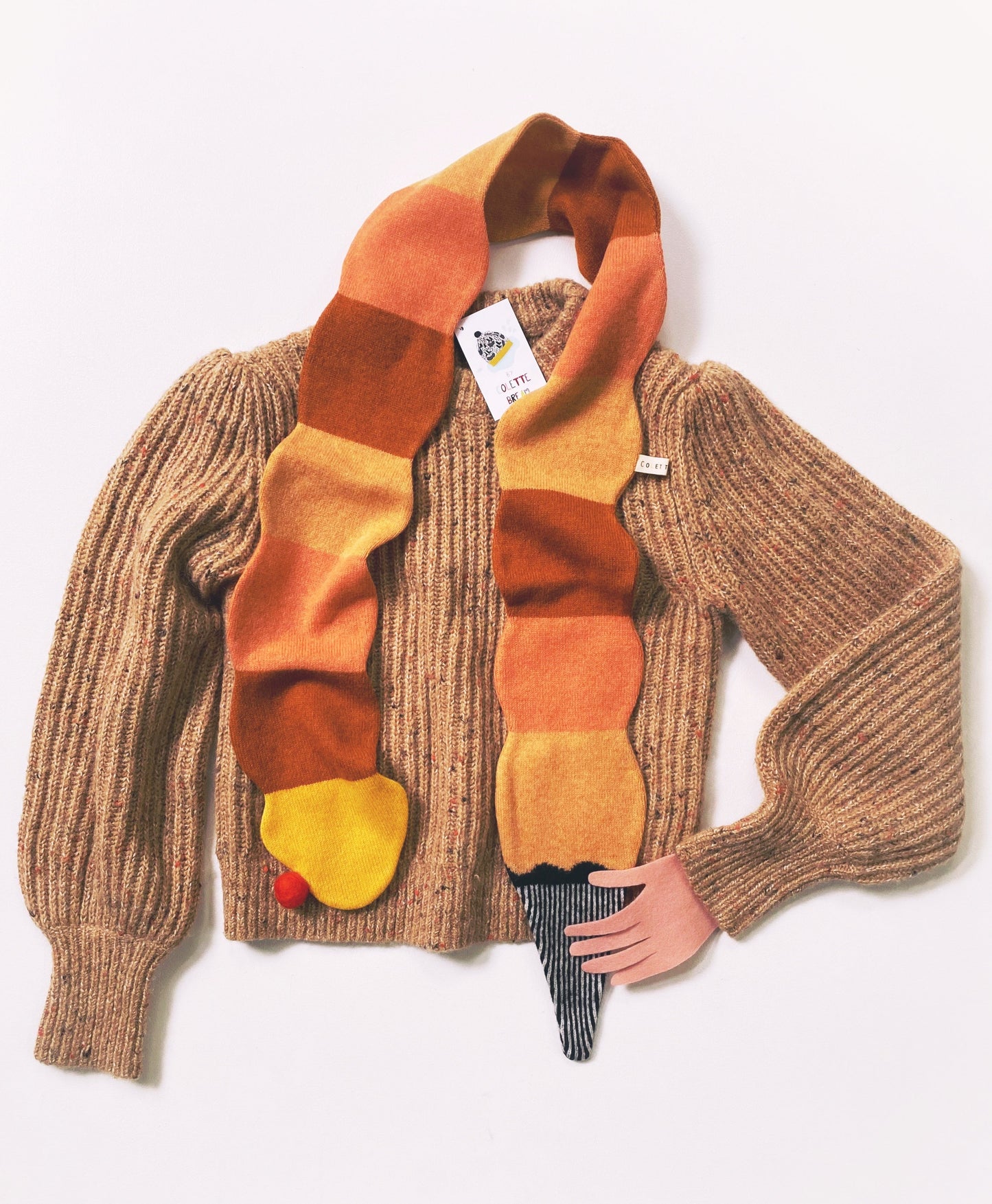 Brown sweater with a colorful knitted lambswool scarf shaped like an ice cream on a white background