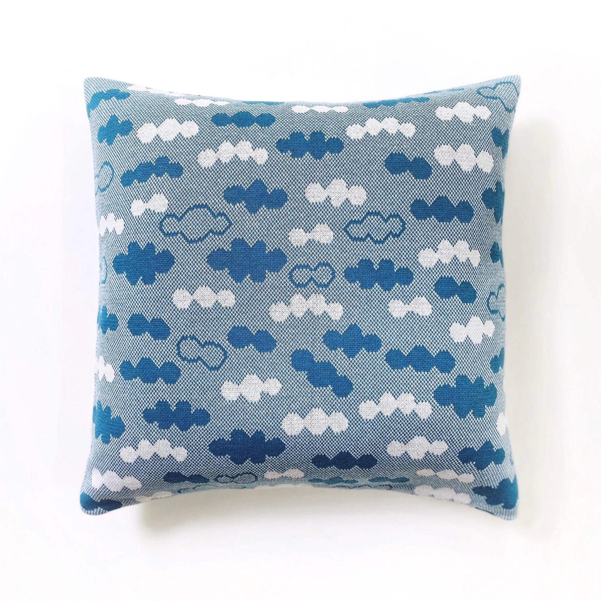 Decorative pillow with blue and white cloud pattern on a white background