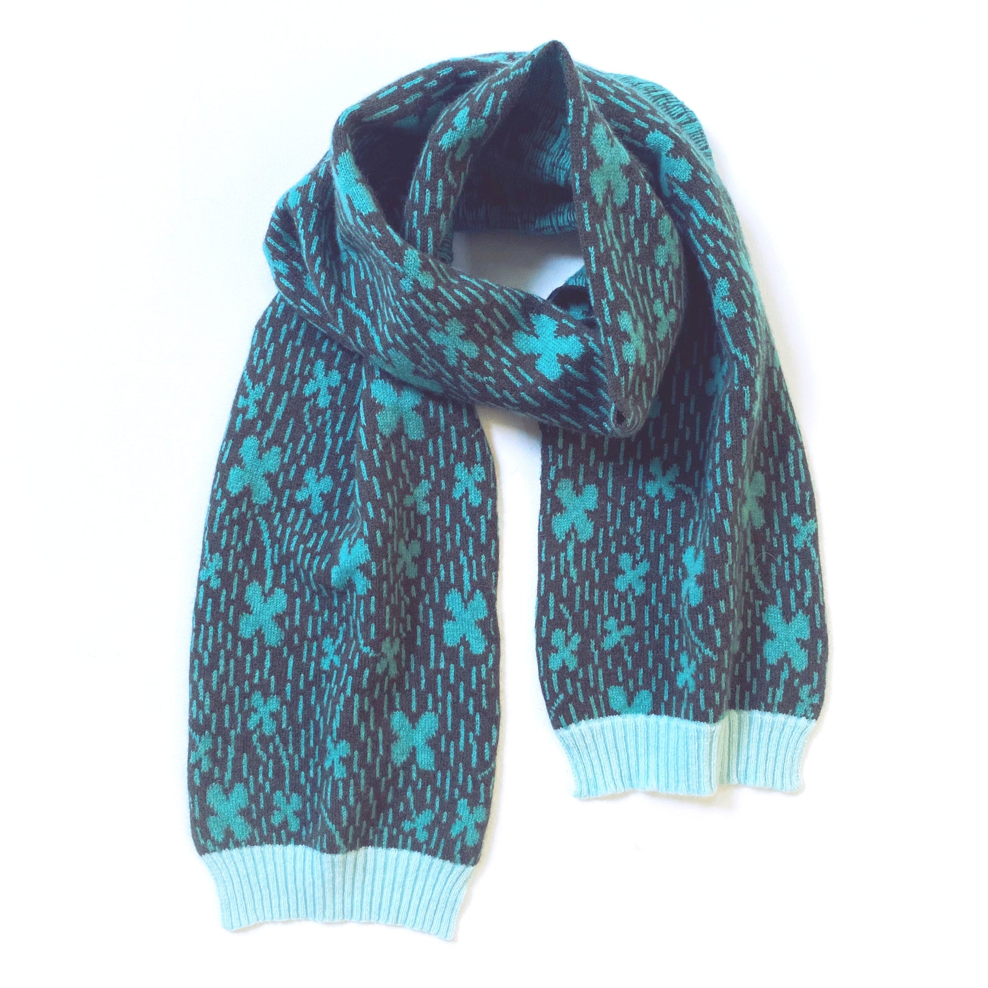 Colorful knitted lambswool scarf with clovefield pattern and shamrocks on white background