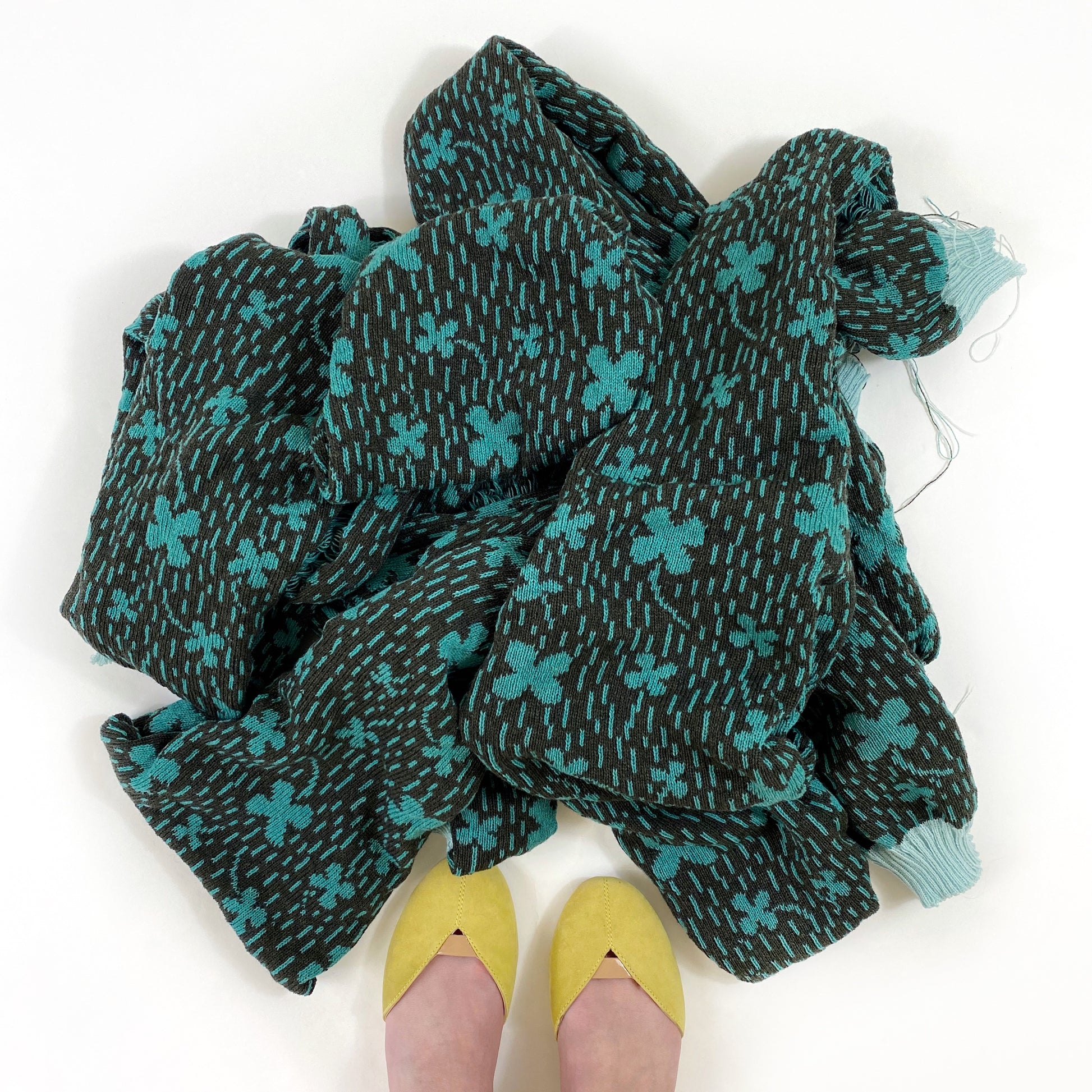 Green and blue patterned lambswool scarf with cloverfield pattern on a white background