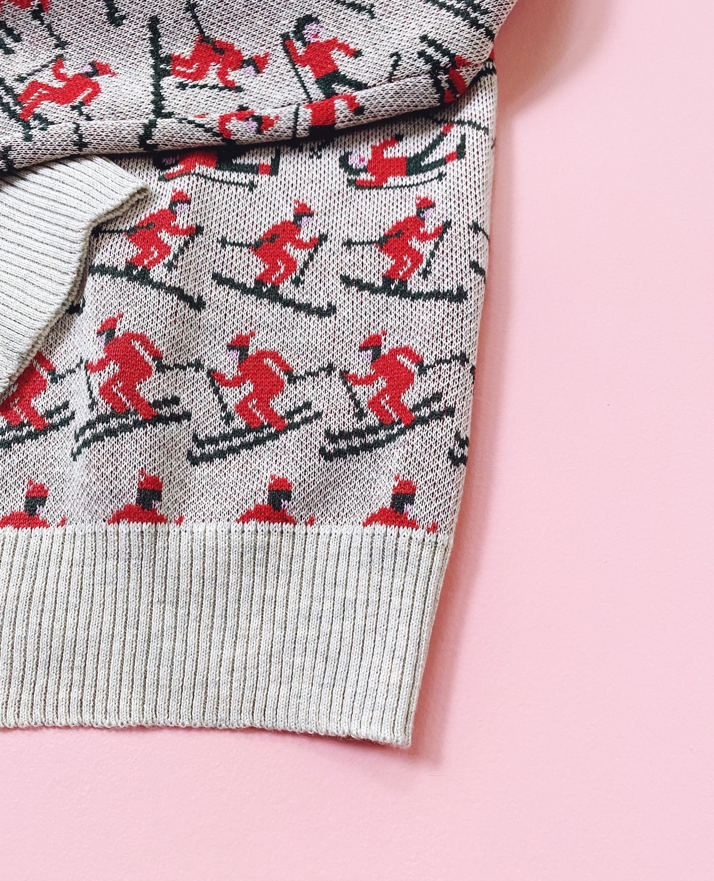 Sweater with skier pattern on a pink background