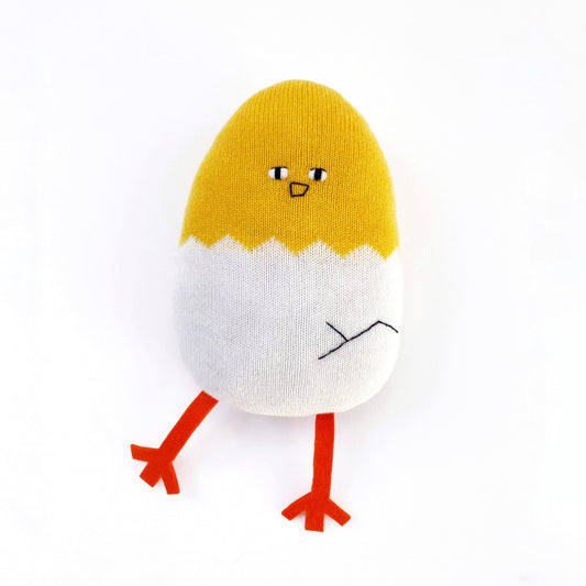 Knitted lambswool toy resembling a chick and an egg with a yellow top and white bottom on a white background