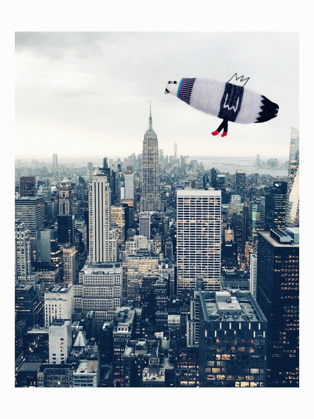 Soft knitted lambswool pigeon stuffed animal plush against big city skyline