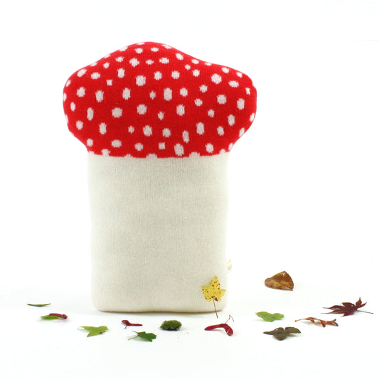 Red and white mushroom knitted pillow on a white background