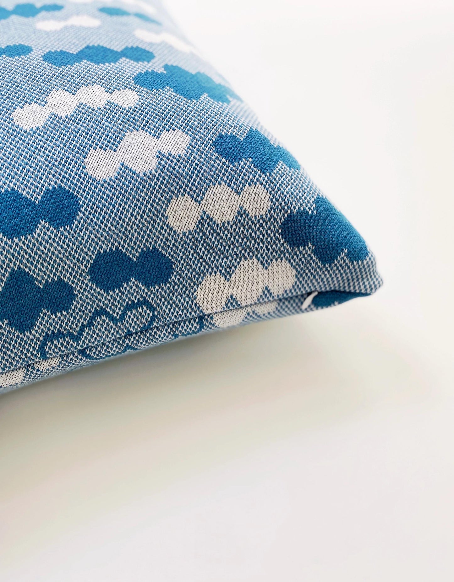 Knitted fabric with blue and white cloud pattern on a light background