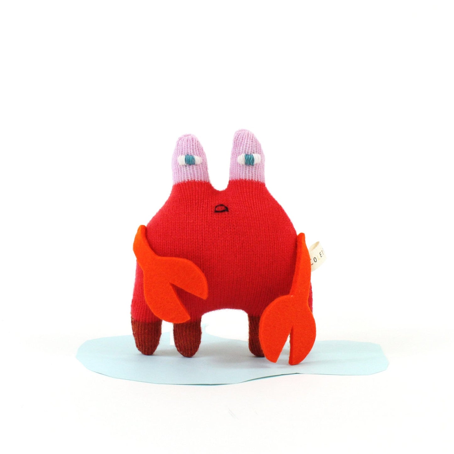 Red knitted lambswool crab toy on a white background