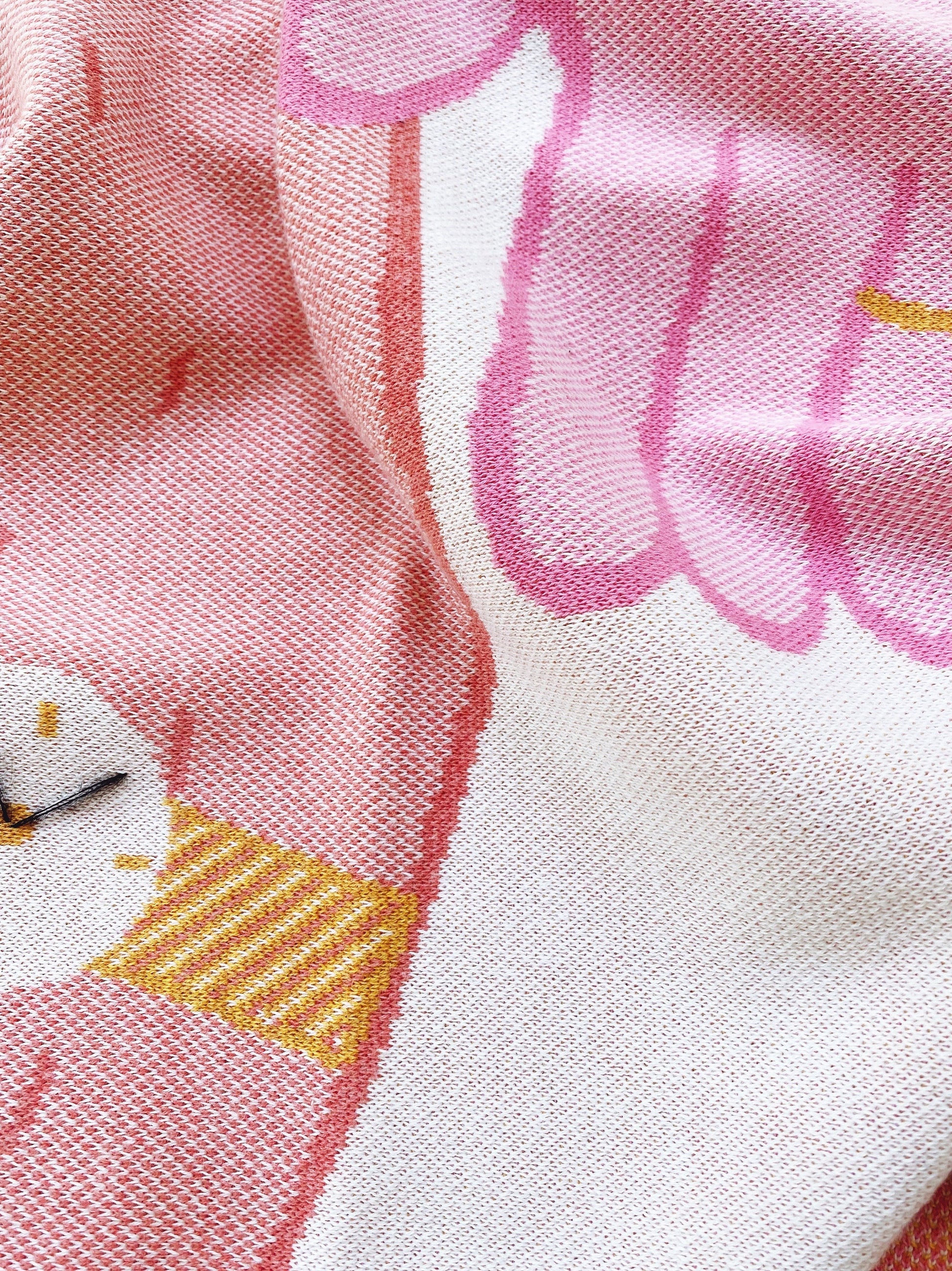 Close-up of a knit fabric with pink pattern and a white background