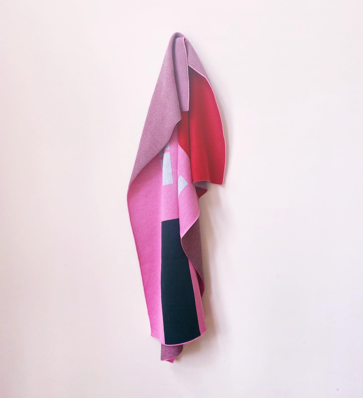 Colorful knitted blanket with house pattern design on white background