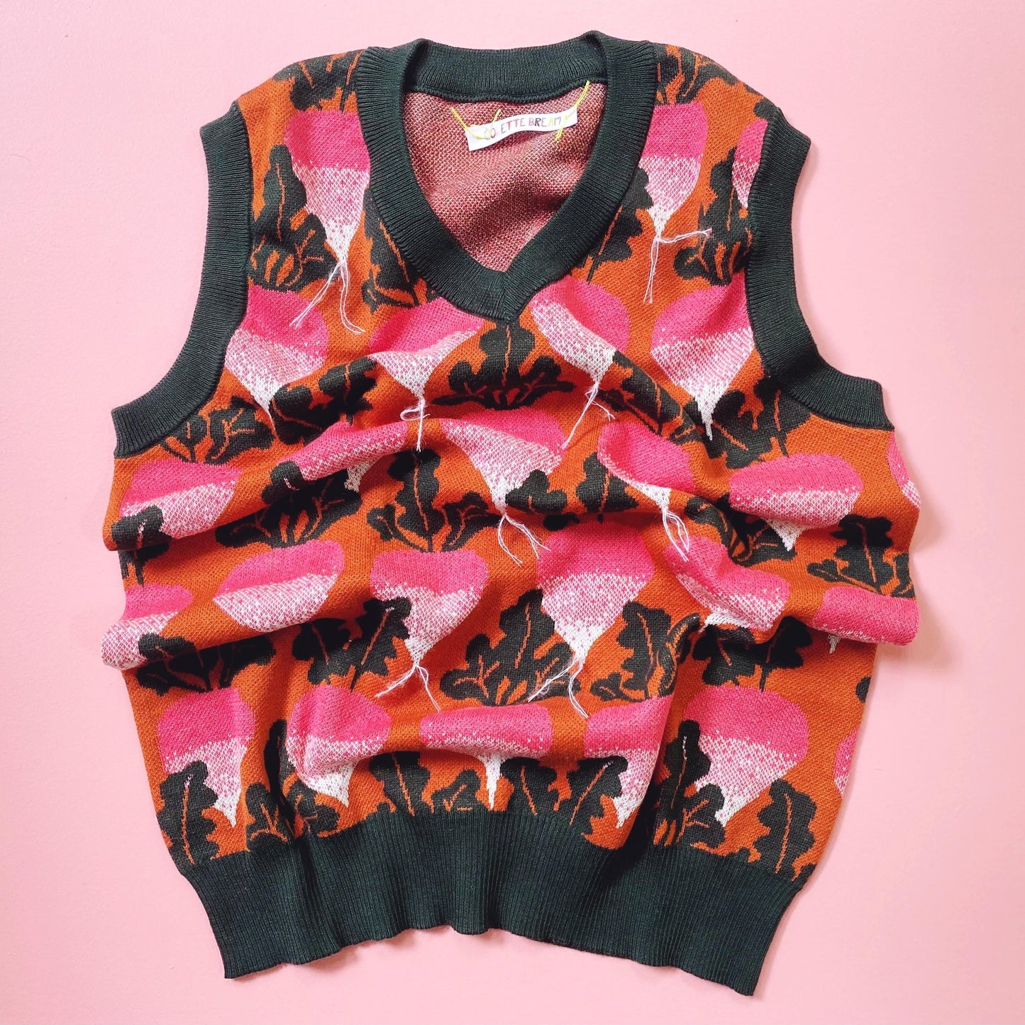 Colorful beets radishes patterned sweater vest on a pink background