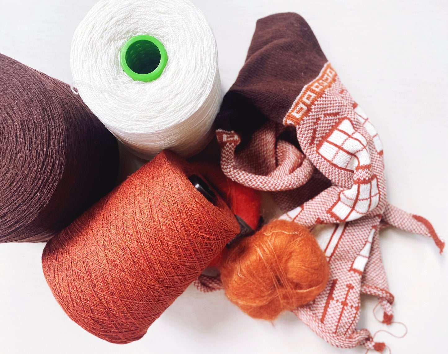Spools of yarn in various colors on a white background