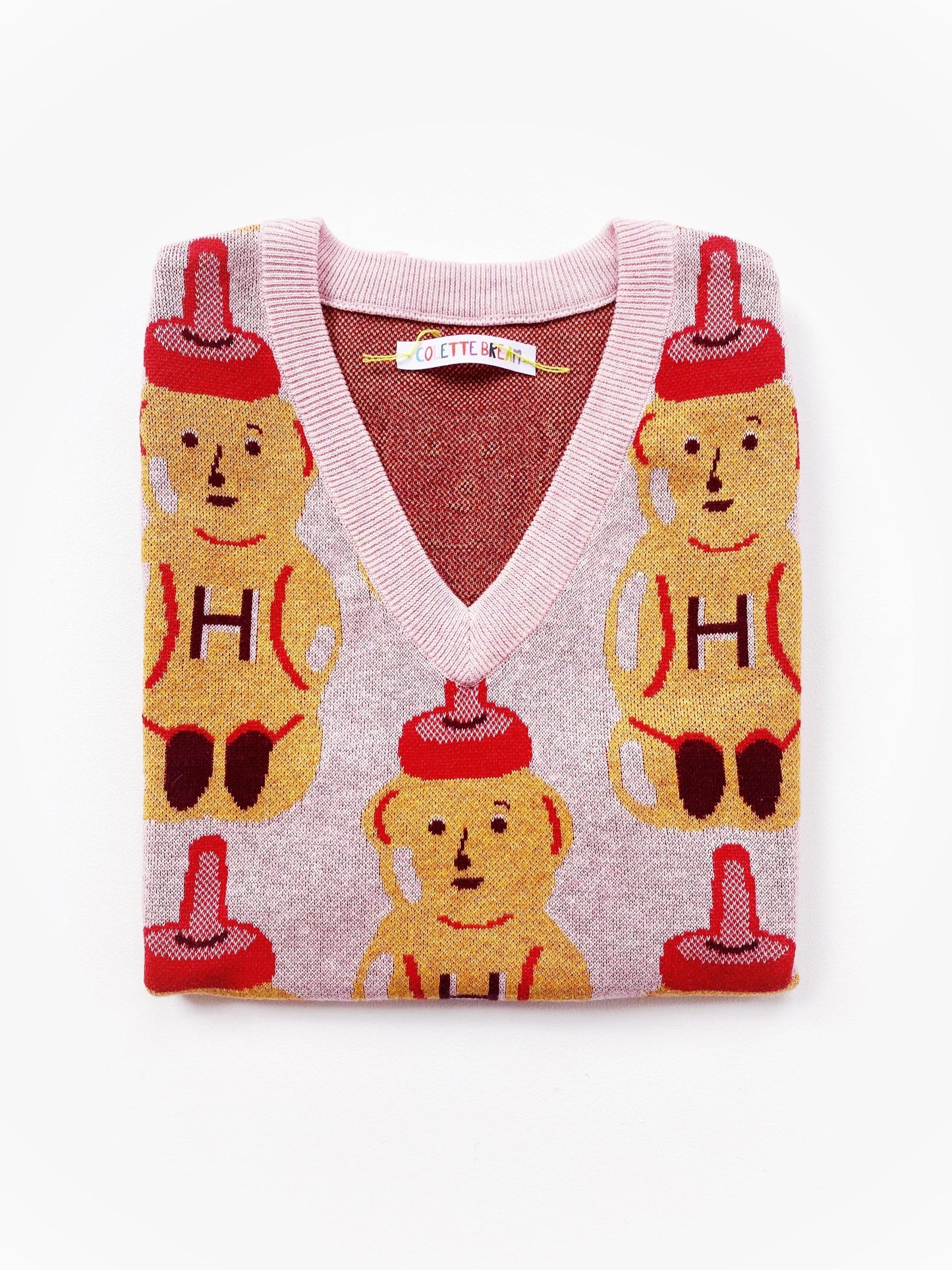 Knitted sweater vest with honey bear design on a white background