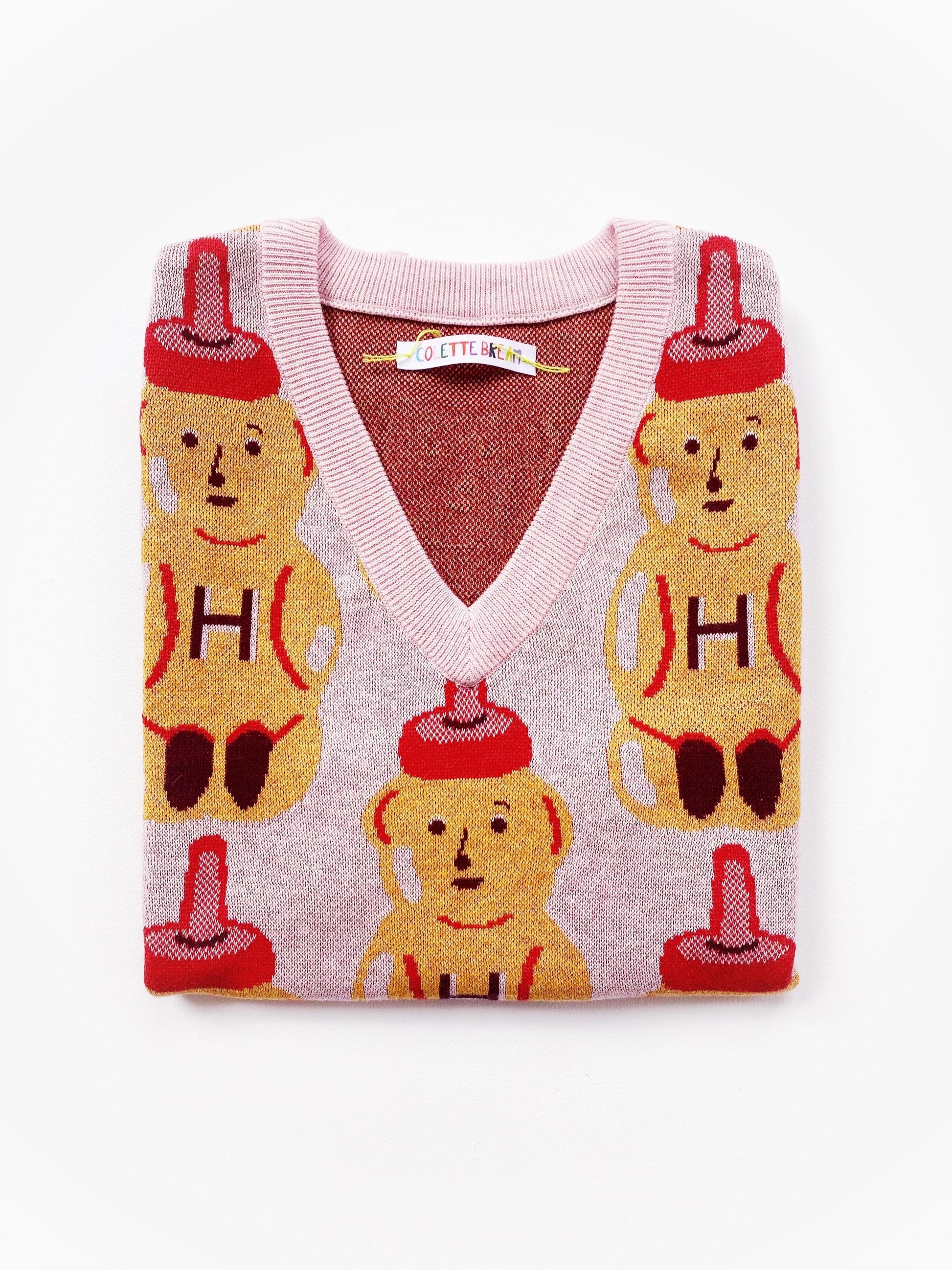 Knitted sweater vest with honey bear design on a white background