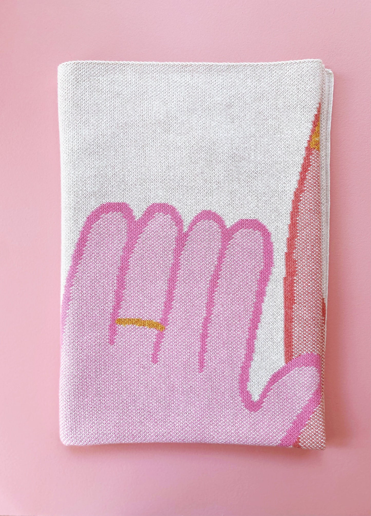 Folded knit fabric with pink design on a pink background