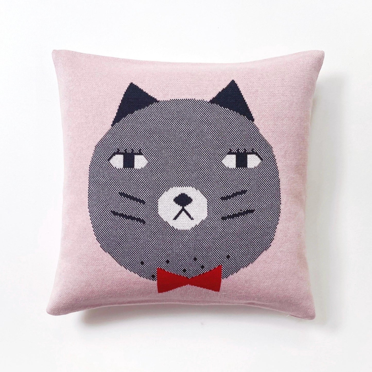 Knitted cushion with a cat face design on a pink background