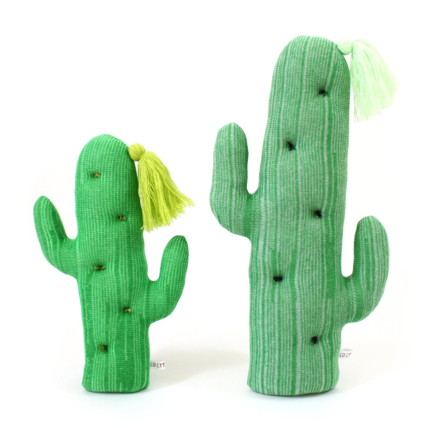 Two green cactus-shaped plush toys with yellow tassels on a white background