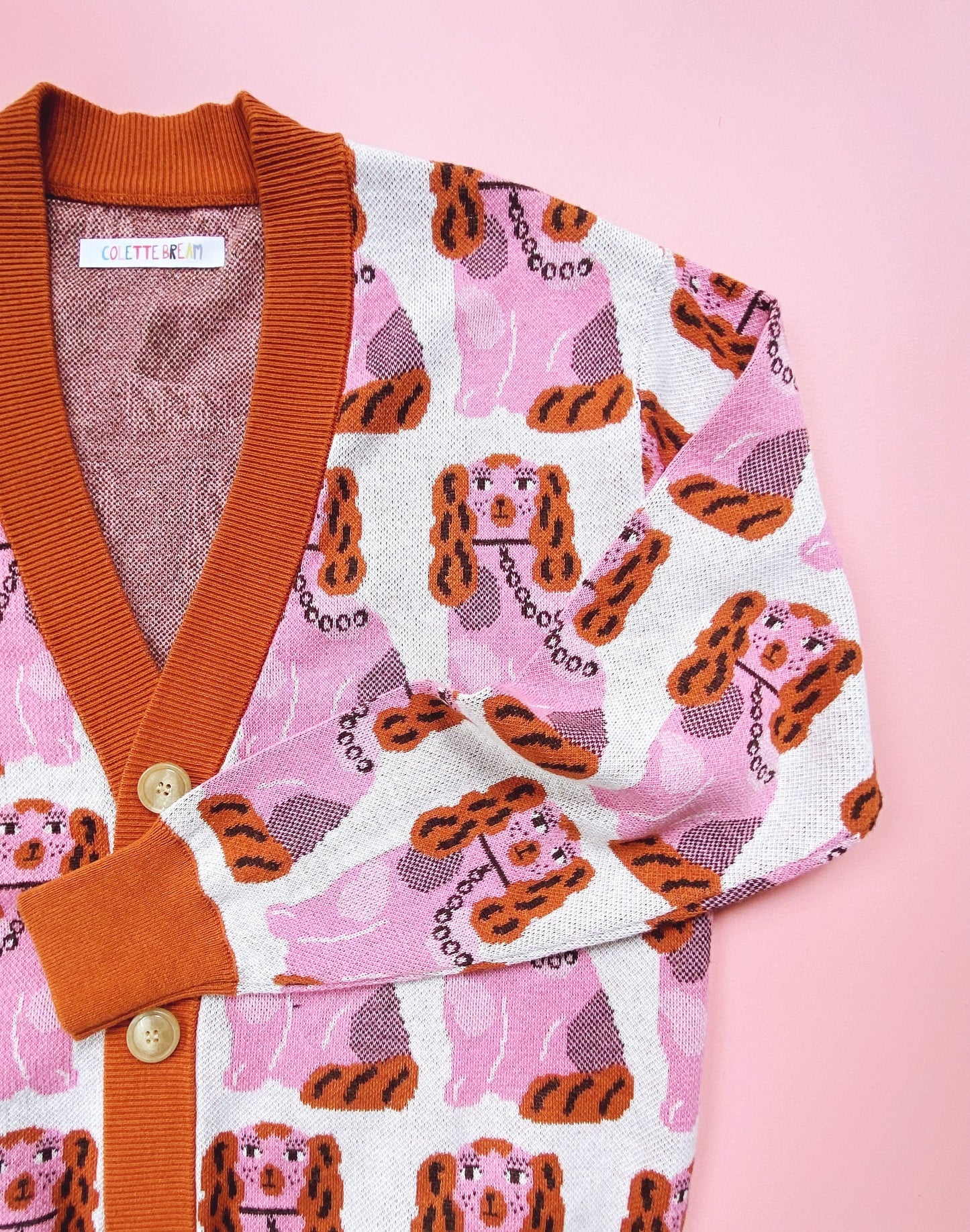 Cardigan sweater with staffordshire dog pattern on a pink background