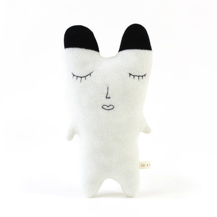 White knitted polar bear plush toy with black ears on a white background