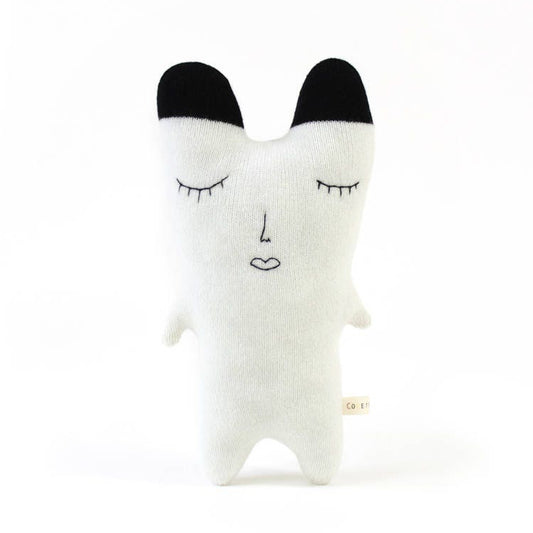 White knitted polar bear plush toy with black ears on a white background